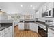 Open kitchen with stainless appliances, granite countertops, white cabinets, and hardwood floors at 11507 Rabbit Ridge Rd, Charlotte, NC 28270