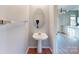 Bathroom with a pedestal sink, wood floors, and large mirror at 11630 Retriever Way, Charlotte, NC 28269