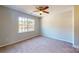 Bright bedroom with a ceiling fan, large window, and neutral carpet at 11630 Retriever Way, Charlotte, NC 28269