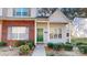 Charming townhome featuring a brick facade, green door, and well-maintained landscaping at 11630 Retriever Way, Charlotte, NC 28269