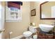 Cozy half bathroom featuring a pedestal sink, decorative mirror, and a window with a view of the outdoors at 1214 Foxfield Rd, Waxhaw, NC 28173