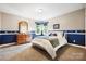 Bedroom with neutral walls, blue accents, and a dresser with a decorative mirror at 1214 Foxfield Rd, Waxhaw, NC 28173