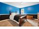Bedroom featuring bold blue walls, black trim, and a wooden chest at the foot of the bed at 1214 Foxfield Rd, Waxhaw, NC 28173