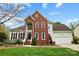 Charming two-story home featuring a brick facade, well-manicured lawn, and inviting curb appeal at 1214 Foxfield Rd, Waxhaw, NC 28173