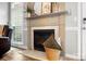 Cozy fireplace with decorative mantle, marble hearth, adjacent to a leather chair and large window at 1214 Foxfield Rd, Waxhaw, NC 28173