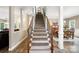 Carpeted staircase with wooden rails and black metal spindles leading to the second floor at 1214 Foxfield Rd, Waxhaw, NC 28173