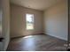 A well-lit bedroom with wood-look floors, a white trim, and a view from the window at 1429 Coppergate Dr, Salisbury, NC 28147