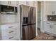 Close-up of the stainless steel refrigerator and pantry in the kitchen, complementing the white cabinets and subway tile backsplash at 1429 Coppergate Dr, Salisbury, NC 28147