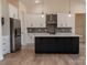 Stylish kitchen featuring white cabinetry, a black kitchen island, and stainless steel appliances at 1429 Coppergate Dr, Salisbury, NC 28147