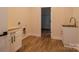 A spacious laundry room featuring custom cabinets, a stainless steel sink, and wood-look flooring at 1429 Coppergate Dr, Salisbury, NC 28147