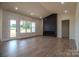 Spacious living room with a modern fireplace, light wood floors, and large windows filling the space with natural light at 1429 Coppergate Dr, Salisbury, NC 28147