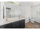 Bright bathroom with a double sink vanity, framed mirror, and tile flooring at 14328 Evening Flight Ln, Charlotte, NC 28262