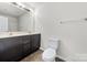 Well-lit bathroom featuring a double sink vanity and neutral walls at 14328 Evening Flight Ln, Charlotte, NC 28262