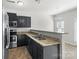 Modern kitchen with stainless steel appliances, dark cabinetry, and granite countertops, offering a stylish and functional space at 14328 Evening Flight Ln, Charlotte, NC 28262