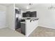 Updated kitchen with stainless steel appliances, a breakfast bar, and dark wood cabinets, ideal for cooking and casual dining at 14328 Evening Flight Ln, Charlotte, NC 28262