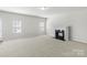 Spacious living room with a fireplace, neutral paint, and large windows offering plenty of natural light at 14328 Evening Flight Ln, Charlotte, NC 28262