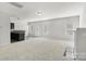 Open-concept living room with neutral carpet, a fireplace, and access to a kitchen bar, perfect for entertaining at 14328 Evening Flight Ln, Charlotte, NC 28262