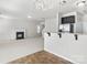 Open-concept living room with fireplace, bar top, stainless steel refrigerator, and neutral color palette at 14328 Evening Flight Ln, Charlotte, NC 28262
