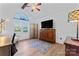 Bright bedroom featuring wood floors, TV, ceiling fan, and arched window at 14827 Smith Rd, Charlotte, NC 28273