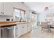 Bright kitchen area featuring stainless steel dishwasher, white cabinetry, and a window view at 14827 Smith Rd, Charlotte, NC 28273