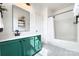 Well-lit bathroom with green vanity, modern fixtures, and combination tub and shower at 14911 Barnsbury Dr, Huntersville, NC 28078