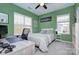 Comfortable bedroom with green walls, neutral carpet, and a dedicated desk area at 14911 Barnsbury Dr, Huntersville, NC 28078
