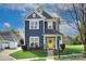 Beautiful two-story home with vibrant yellow door, fresh landscaping, and a welcoming front porch at 14911 Barnsbury Dr, Huntersville, NC 28078