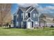 Charming two-story home with a well-maintained lawn, a cozy patio, and a mix of residential and natural scenery at 14911 Barnsbury Dr, Huntersville, NC 28078
