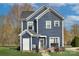 Two-story home featuring a well-kept lawn, an inviting patio setup, and a charming exterior architectural design at 14911 Barnsbury Dr, Huntersville, NC 28078