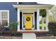 Welcoming front porch with a vibrant yellow door, decorative wreath, and neat landscaping at 14911 Barnsbury Dr, Huntersville, NC 28078