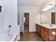 Bathroom with double sink vanity, neutral walls, soaking tub and tile flooring at 15506 Lakepoint Forest Dr, Charlotte, NC 28278