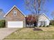 Home with stone accents, attached two-car garage, well manicured lawn, and mature landscaping at 15506 Lakepoint Forest Dr, Charlotte, NC 28278