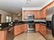 Efficient kitchen featuring stainless steel appliances, granite countertops, ample wood cabinets, and tile flooring at 15506 Lakepoint Forest Dr, Charlotte, NC 28278