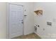 A utility room features an exterior door, simple shelf, and hook to hang coats at 15506 Lakepoint Forest Dr, Charlotte, NC 28278