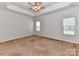 Spacious main bedroom with carpet flooring, a ceiling fan, and large windows at 15506 Lakepoint Forest Dr, Charlotte, NC 28278