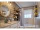 Stylish bathroom with a modern vanity, round mirror, wooden wall accents, and a bathtub with a shower curtain at 198 33Rd Nw St, Hickory, NC 28601