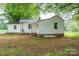 The side of the home features white siding and a brick foundation, surrounded by mature trees at 201 Lee Black Rd, Cherryville, NC 28021