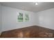 Bedroom featuring wood floors, white trim, and backyard views from windows at 201 Lee Black Rd, Cherryville, NC 28021