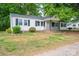 Charming home featuring black shutters, a chimney, and a cozy, covered front porch at 201 Lee Black Rd, Cherryville, NC 28021
