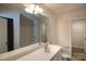 Bright bathroom features a large mirror, tub, shower combo, and ample storage at 2035 Talbert Ct, Charlotte, NC 28214