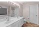 Bright bathroom with a double vanity sink, framed mirror, tub, and shower in a well-lit and spacious layout at 2319 Arbor Vista Dr, Charlotte, NC 28262