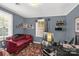 Home office featuring a comfortable red sofa, natural light, and unique decor, creating a personalized workspace at 260 Trexler Ln, Rock Hill, SC 29732