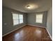 Bright bedroom features two windows, neutral walls, and hardwood flooring at 3316 Queens Ln # 10, Gastonia, NC 28052
