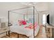 Bright bedroom with a canopy bed, wood floors, and a round window with a lake view at 336 Northwest Dr, Davidson, NC 28036