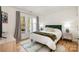 Cozy bedroom with a green headboard, wood floors, and large windows at 336 Northwest Dr, Davidson, NC 28036