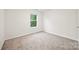 Well-lit bedroom with neutral carpet, window, and white baseboards and walls at 3725 Catawba Creek Dr, Gastonia, NC 28056