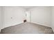 Carpeted bedroom with an open door showing wood floors, white baseboards and walls at 3725 Catawba Creek Dr, Gastonia, NC 28056
