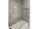 Modern bathroom shower with marbled tile and a tiled shower niche at 3735 Stonehaven Dr, Charlotte, NC 28215