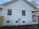 Side view of the house, featuring a white painted brick exterior and neat design at 3735 Stonehaven Dr, Charlotte, NC 28215