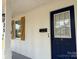 View of the front porch featuring a freshly painted blue door and rustic shutters at 3735 Stonehaven Dr, Charlotte, NC 28215